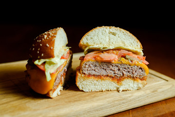 two halves of a burger on black background