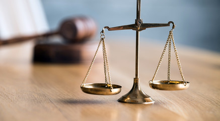 Law and Justice concept. Gavel of the judge, books, scales of justice. Gray stone background.