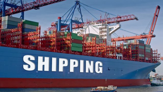 Container ship is being loaded in a harbor. The lettering "shipping" was digitally inserted on the side of the vessel