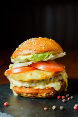 hamburger with chicken, pineapple and vegetables on a plate