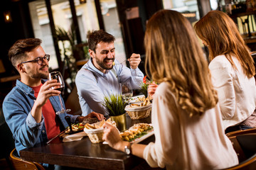 Group of young people having dinner in the restaurant