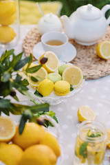 Lemons and yellow macaroons on the table. Copy space. The concept of spring and summer season. Healthy Food and Drink. Italian or spanish picnic decoration.