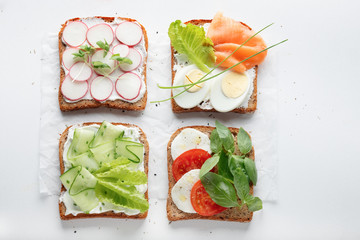 sandwiches with mascarpone cheese, cucumber, radish, eggs, caprese salad, salmon on a white background.