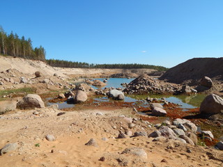 Summer landscape with water, sand, stones and a blue sky on a sunny day, beautiful view