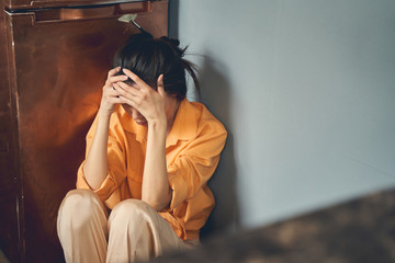 Upset young woman sitting on the floor at home
