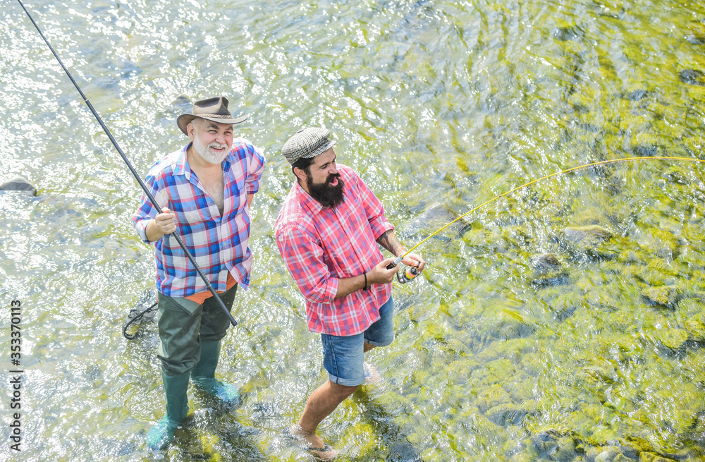 Wall mural Go far together. Camping on the shore of lake. Big game fishing. friendship. happy fisherman with fishing rod and net. concept of a rural getaway. hobby. wild nature. father and son fishing. Poaching