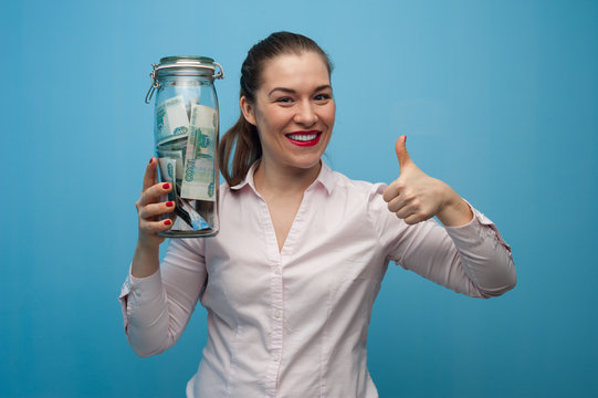 Young Charming Woman Holds A Jar With Money