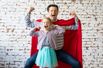 happy father in superhero costume and his daughter