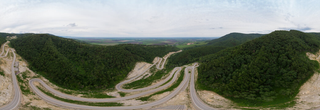 Full 360 equirectangular spherical panorama of aerial top vew of winding road in the mountains, drone shot. Altai Krai, Western Siberia, Russia. Road to Resort town Belokurikha 2. Virtual reality