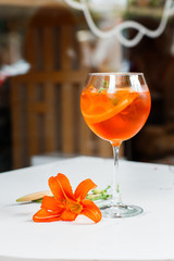 Naklejka premium Aperol spritz cocktail in glass on table. italian alcoholic cocktail isolated on wooden background. orange cocktail. Bar menu. Overhead view, copy space. Advertising for cafe menu.
