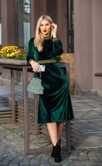 Girl carry handbag. Glamorous clutch accessory. Fashion blog. Elegant woman in green velour dress. Velvet fashion trend. Silk velvet. Glamour velvet textile. Sexy woman outdoors. modern life