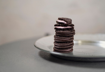 Chocolate cookies with filling on a silver plate close up, tasty treat for kids and adults
