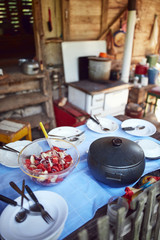Rustic cottage with outdoor kitchen table ready for summertime lunch.