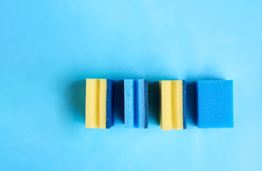 Yellow and blue sponges on a blue background. Space for text