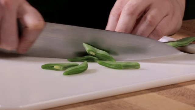 woman chef cutting green beans close up