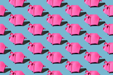 Origami pink paper pigs isolated on blue background with hard shadow, colorful seamless pattern.