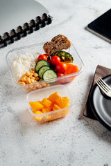 Healthy food in lunch box, on working table with laptop