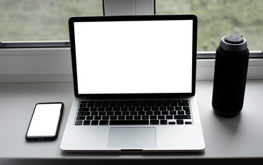 laptop with white screen for text on the window with phone and books