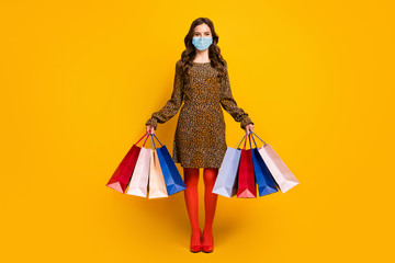 Full length body size view of her she nice attractive rich wealthy wavy-haired lady carrying new clothes garment wearing mask quarantine isolated bright vivid shine vibrant yellow color background