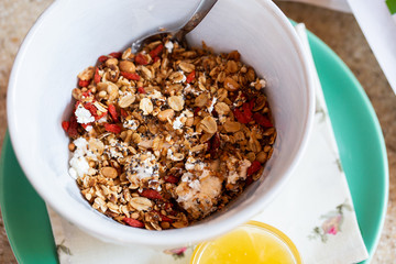 Healthy food background with homemade oatmeal granola or muesli with cottage cheese on white bowl and honey for healthy morning breakfast, top view, copy space. Breakfast and healthy concept.