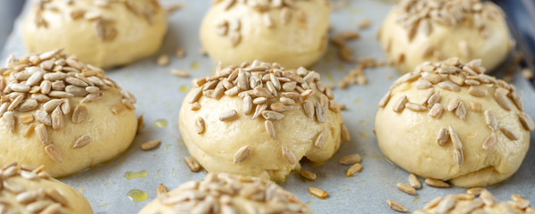 Raw yeast buns with seeds before baking. Cooking homemade buns. Soft focus