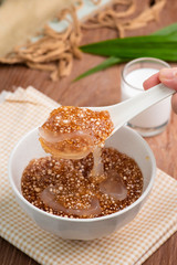 Thai dessert ,Tapioca pearl or Sago pudding with coconut meat in coconut milk on wooden table.