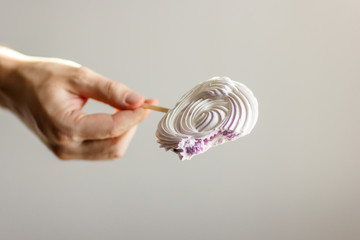 bitten candy on a white stick in the right male hand