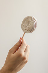 white round lollipop in the right male hand