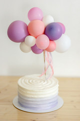 beautiful white cake with balloon topper