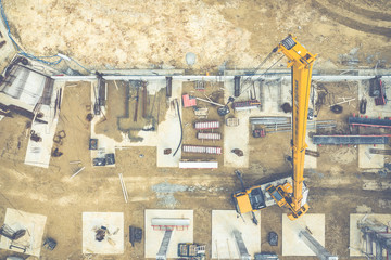 Construction site from above. Aerial view of workplaces in construction equipment, workers with heavy machinery. Industrial top view made by drone.