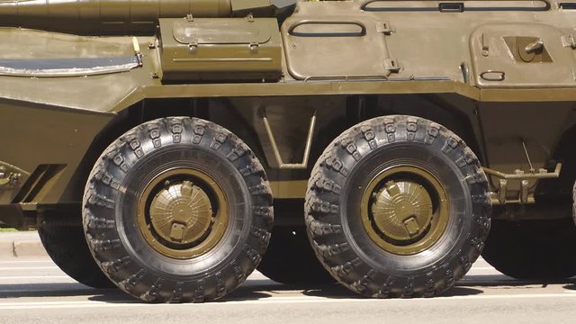 Close-up of rubber tires of an armored personnel carrier, rubber tires with a large tread to overcome impassable roads and mud, Russian-made armored personnel carrier on a Sunny day. Military