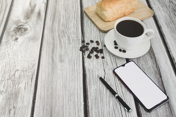 Black coffee, bread, telephone on a white wood floor with free space.