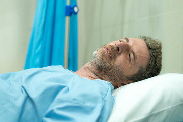 Obraz premium scared and worried man in pain at hospital room - attractive injured man lying on bed suffering painful problem sick and stressed after suffering accident or serious disease