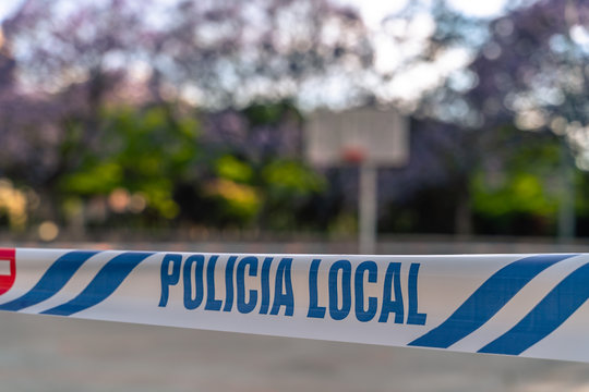 Closed basketball field at the park. Spanish Local police restriction tapes around empty field due to COVID-19 coronavirus pandemic.