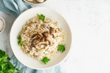 Risotto with mushrooms in plate. Rice porridge with mushrooms and parsley