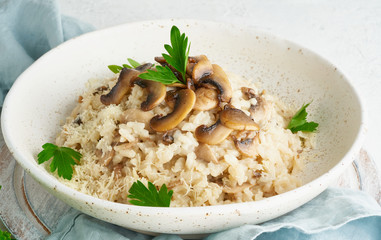 Risotto with mushrooms in plate. Rice porridge with mushrooms and parsley