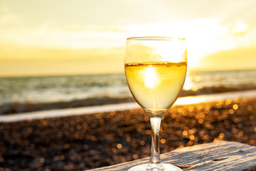 Glass of champagne at sunset on a background of the sea.