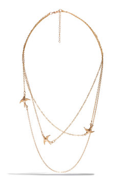 Detailed shot of a golden multi-row necklace with metal inserts in the form of flying birds and a lobster clasp. The delicate piece of jewelry is isolated on the white background.