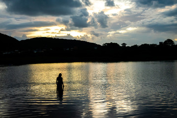Naklejka na ściany i meble silhouette of a man on a lake