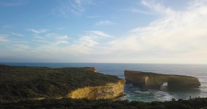 Aerial view of the London Arch at the Port Campbell National Park in Victoria, Australia at sunset with light coming from the ocean.