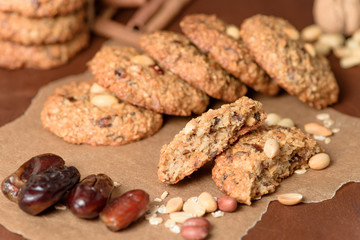 homemade oatmeal cookies with dates, peanuts, coconut shavings on a wooden background, macro close-up. broken cookies in the foreground