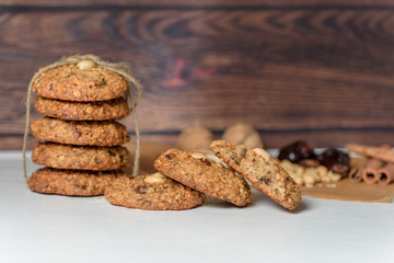homemade oatmeal cookies with dates, peanuts, coconut shavings on a wooden background, macro close-up. broken cookies in the foreground. space for text