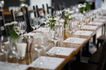 Tables setting at a luxury wedding. Table for guests. Dishes and drinks. Floral decorating, white chairs and table. Wedding table preparation. top view. Horizontal photo