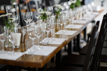 Tables setting at a luxury wedding. Table for guests. Dishes and drinks. Floral decorating, white chairs and table. Wedding table preparation. top view. Horizontal photo