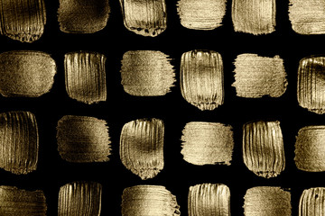 Creative brushstrokes of gold paint isolated on a black background. Gold paint texture.Acrylic gold...