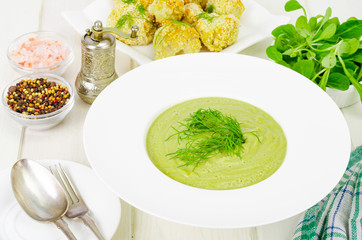 White plate with cream soup of green vegetables, healthy diet dish.