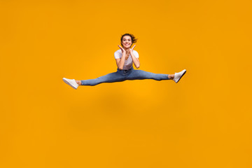 Full length body size view of her she nice attractive lovely sporty slender cheerful cheery girl jumping doing exercise twine having fun isolated on bright vivid shine vibrant yellow color background