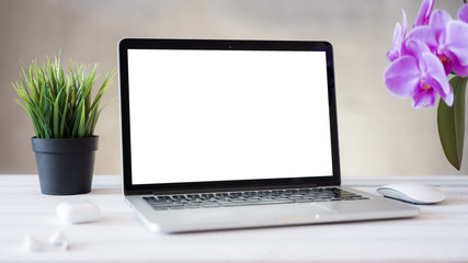 Fototapeta premium Laptop computer white blank screen on work table front view. Copy space, home and office workspace concept, laptop mockup.