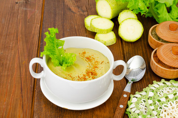 Green zucchini cream soup in cup. Photo
