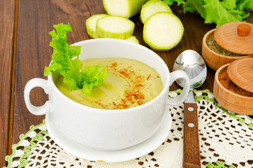 Green zucchini cream soup in cup. Photo